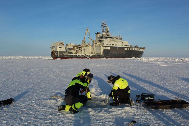 Toktbilde frå Arven etter Nansen 2021, med forskningsfartøyet Kronprins Haakon i bakgrunnen. Forskere arbeider på isen med lite eller ingen snødekke på. (Se bilde lenger ned for å sammenligne)