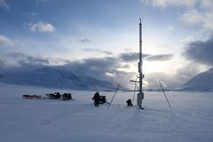 Bilde av en målestasjoner på Svalbard, tatt tidlig i april. Da var det fortsatt litt snø.