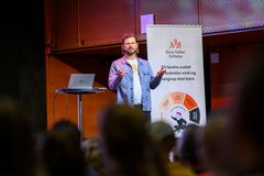 mann står på scenen foran publikum