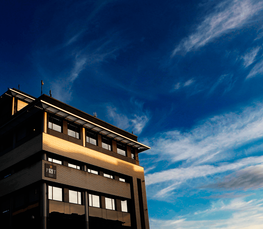 Illustrasjonsfoto: PSTs hovedkontorbygg mot mørkblå skumringshimmel.