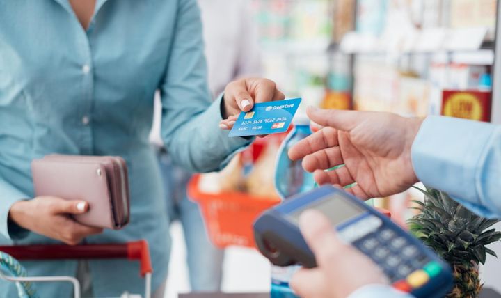En kvinne som betaler med kredittkort i butikk.