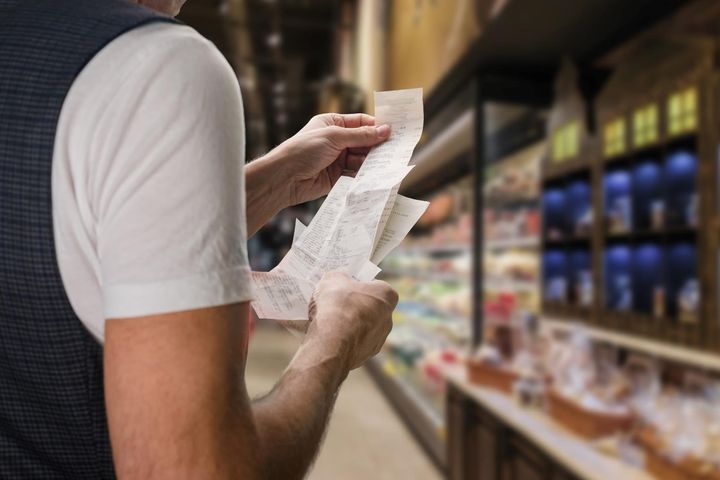 Person som ser på kvitteringer i forbindelse med handletur i butikken.