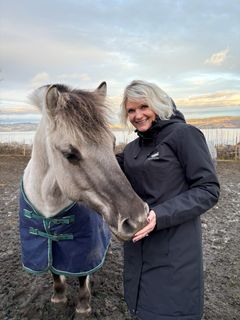 Camilla Garmann administrenrede direktør i Norsk Rikstoto,  med en fjordhest; en norsk hesterase som er kritisk truet.