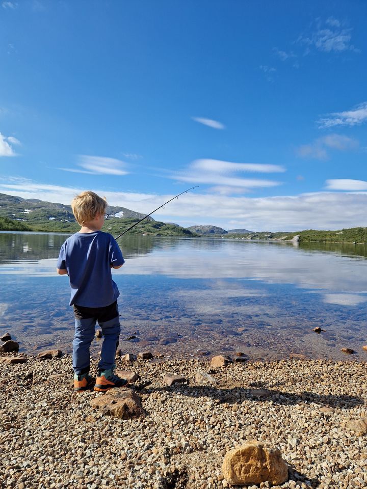 Barn som fisker med fiskestang