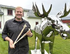 Storviltforvalter står foran campus Evenstad med en elgkjeve i hånden.