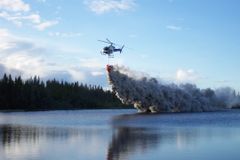 Helikopter slipper kalk over en innsjø, for å motvirke forsuring som kommer av sur nedbør.