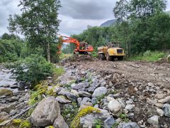 Gravemaskin ved elv.