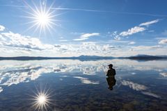 Mann som fisker i elv.