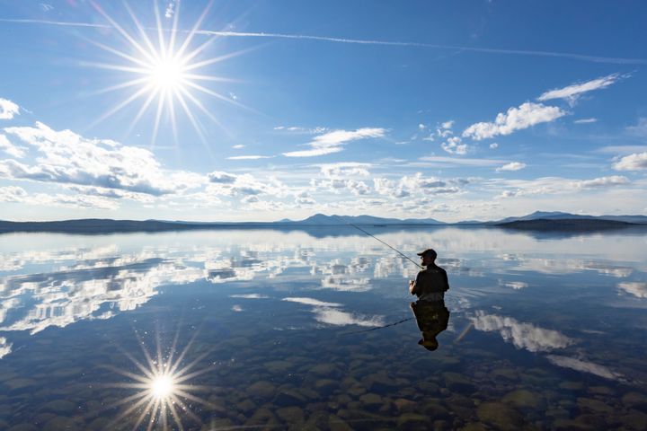 Mann som fisker i elv.