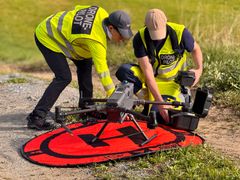 Sean Salazar og Eivind Magnus Paulsen klargjøre dronen for LiDAR-kartlegging av ravinen ved Bjørke i Ullensaker kommune.