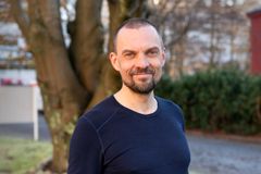 Mann smiler mot kamera.