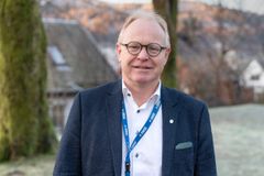 mann med briller smiler mot kamera