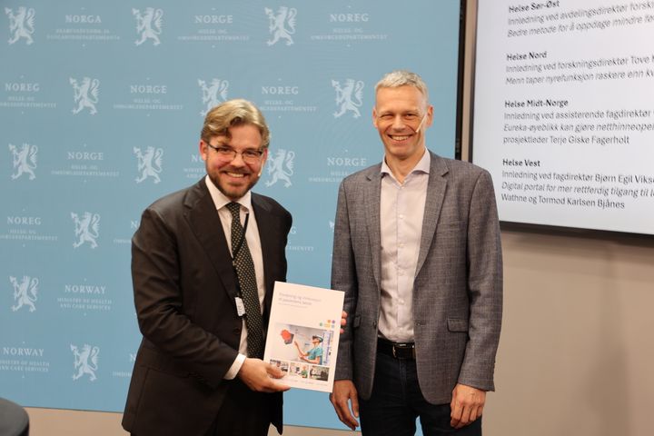 Ole Martin Juul Slyngstadli, statssekretær i Helse- og omsorgsdepartementet , og Bjørn Egil Vikse, fagdirektør i Helse Vest RHF under overrekkelsen av rapporten.