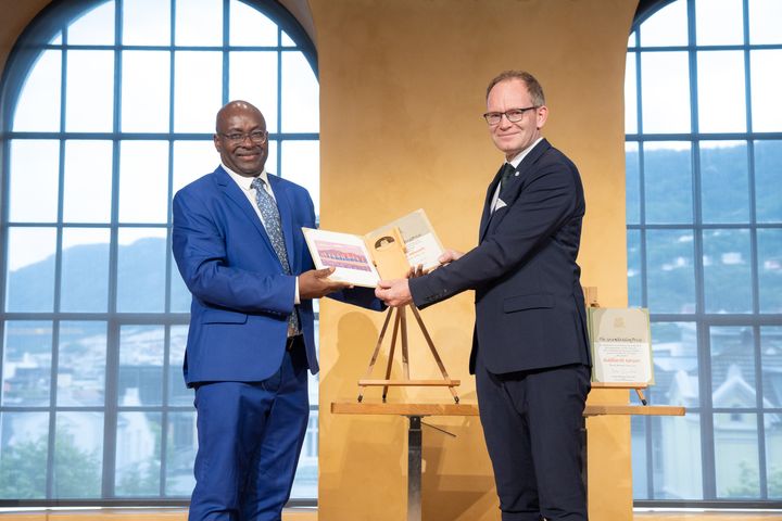 Prisvinner Achille Mbembe får Holbergprisen av Forsknings- og høyere utdanningsminister Oddmund Hoel (Sp).