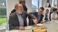 Forsknings- og høyere utdanningsminister Oddmund Hoel (Sp) og kommunal- og distriktsminister Erling Sande (Sp) spretter kaken på sentralsjukehuset i Førde. I bakgrunnen Sunnfjord-ordfører Jenny Følling (Sp).