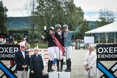En glad trio juniorryttere på pallen - fra venstre Madelen Ossletten Fuglstad, Amalie Marie Litland og Linnea Tomelthy Storstrøm - sammen med NRYFs president Tore Sannum, overdommer Lill Svele og sprangdommer Marianne Tveter.
