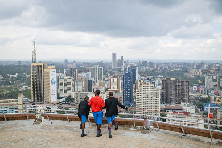 Tre skoleelever i uniform står på et tak og ser utover Nairobis skyline. Utdanning og jobbskaping er viktige ingredienser for å sikre at unge afrikanere skal slippe å leve i fattigdom.