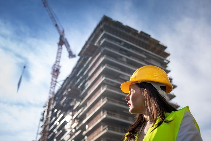 Ung kvinne med verneutstyr på byggeplass