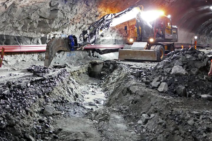 Bildet viser oppgravd veg inne i tunnelen og gravemaskin.