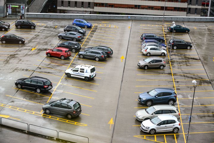 Bildet viser en parkeringsplass med flere biler.