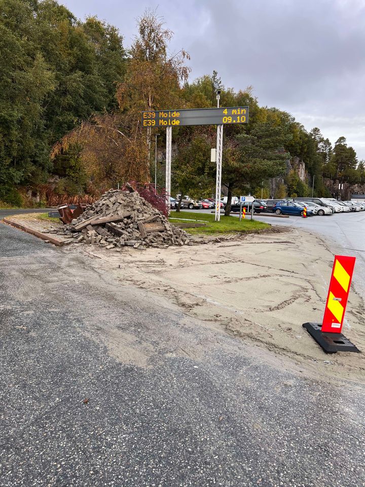 Bilde fra E39 Vestnes ferjekai hvor arbeidsvarsling er satt ut og entreprenør har begynt å fjerne stein.