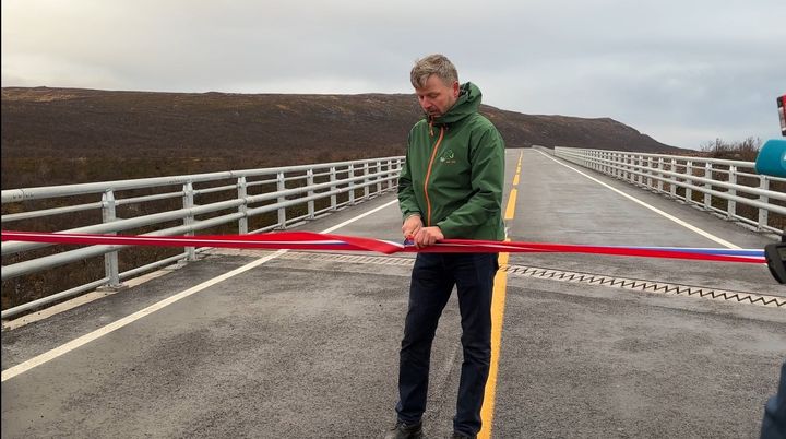 Statssekretær Stein Mathisen klipte snora og åpnet den nye vegstrekningen på E6 i Finnmark med ny bru over Vuolmmašjohka.