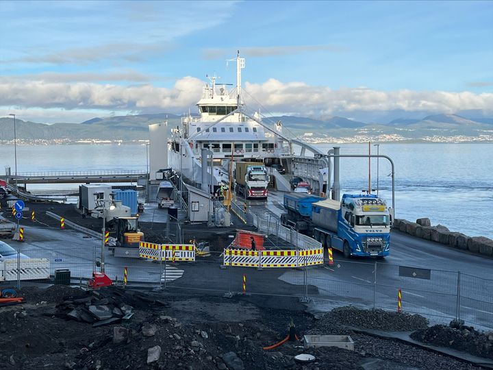 Bilete av anleggsarbeida som skjer på ferjekaia. På biletet kjører samtidig køyretøy av ferja.