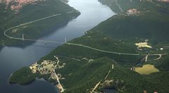 Bildet er en illustrasjon over hvordan ny E6 vil se ut når det er bygget bru over Sørfjorden. Bildeteksten sier, P2: Hengebru over Sørfjorden med tilstøtende tunneler er en del av byggetrinn to i prosjektet E6 Megården-Mørsvikbotn.