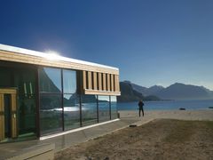 Naturen speiler seg i glassfasaden på bygget.