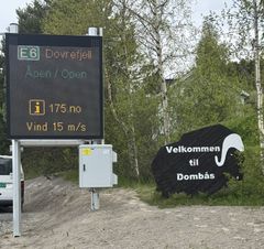 Digital skilttavle i vegkanten med tekst: E6 Dovrefjell Åpen/Open og Vind 15/m/s.