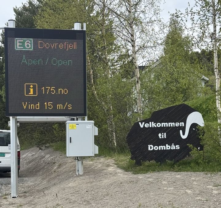 Digital skilttavle i vegkanten med tekst: E6 Dovrefjell Åpen/Open og Vind 15/m/s.