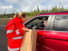 Vegdirektør Ingrid Dahl Hovland deler ut blomster til den første bilen som passerte etter den offisielle åpningen av vegen.