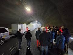 Bildet viser røyk fra en biltilhenger med røykmaskin og en gruppe fagfolk som følger med på testen. Bildeteksten sier, Stresstest: Her testes viftekjøring og overvåkingssystemet i Bergåstunnelen på E6 Svenningelv-Lien. Serveren som skal varsle Vegtrafikksentralen (VTS) og stenge tunnelen ved brann og ulykker, kollapset en måned ut i testperioden.