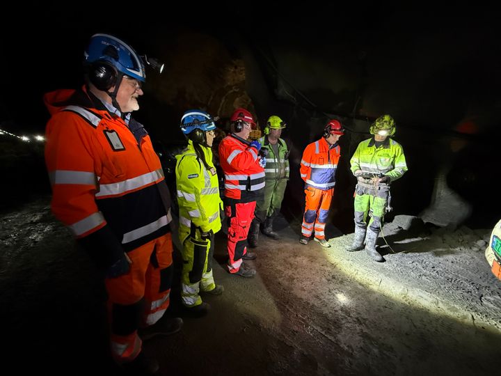 Bildet viser seks personer i verneutstyr inne i Fiskefjordtunnelen som gjør seg klar til å skyte siste salve. Bildeteksten sier, Ordfører i Lødingen, Hugo Bongard Jacobsen (Ap), gjør seg klar til å fyre av den siste salven i Fiskefjordtunnelen. Fv: Are Eliassen, prosjektdirektør i Skanska Norge AS, Ida Tryland Haugland, Hæhre AS, Alf Harrald Barosen, Statens vegvesen, Oddleif Tjugen, Skytebas Hæhre AS, Hugo B Jacobsen,  og Nikolai Taraldsen, Stuffreperatør Hæhre AS.