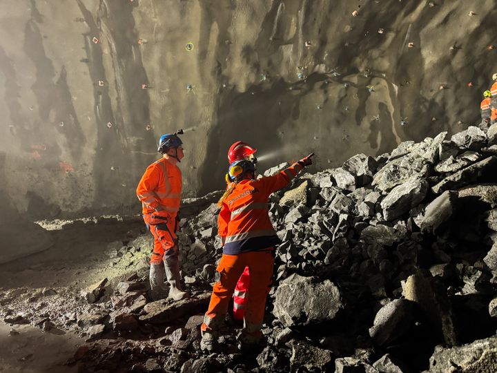 Bilde av ansatt i Skanska som peker opp til åpningen mot den andre siden av Høviktunnelen.