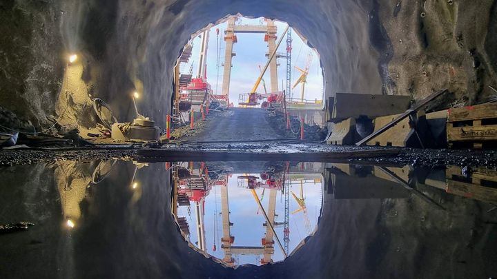 Utsikt frå tunnelportalen i Drotningsvik der riksvegen kjem ut.  Drotningsviktunnelen kjem ut frå fjellet og rett ut på Nye Sotrabru. Tunnelen er hovudsakleg drive frå Storavatnet og vestover med unntak av 50 meter som er drive frå Drotningsviksida. Gårsdagens gjennomslag ligg kring 50 meter inn i tunnelen frå portalen i bilete.