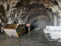 Bildet viser tunnelveggen der gjennomslagssalva gjekk. Den ligg kring 50 meter inn i tunnelen frå Drotningsviksida. Holet gøymer seg under mattane. Heile profilet er innan kort tid nede, og når sprengsteinen er rydda vekk er det lys i begge endar.