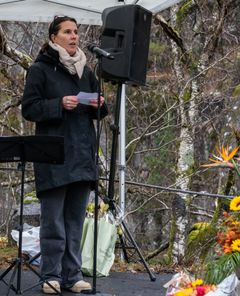 Kvinne står og taler på ei scene.