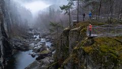 Tre menneske står på to ulike utsiktspunkt og ser ned på elveløpet.