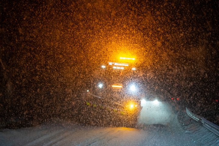 Bilde av en brøytebil i tett snøvær.