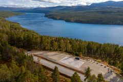 Luftfoto av kunstverket omgitt av skog og fjell.
