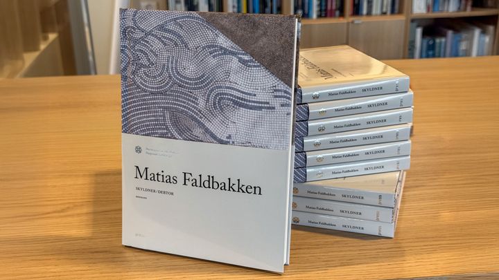 Bildet viser flere eksemplarer av den nye kunstboka liggende på et bord.