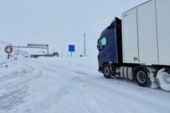 Vogntok som kjører over grensen fra Norge til Sverige på vinteren.