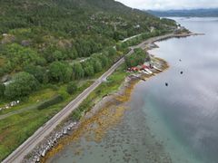 Bildet viser fritidseiendommer på begge sier av rv. 80 og Nordlandsbanen. Bildetektsen sier, Avkjøringer til de mange hyttene langs vegens skal samles og bli færre. Det skal også bygges gangbruer for trygg kryssing av veg og jernbane.