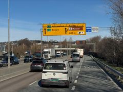 Trafikk som kjører under en skiltportal på motorvei.