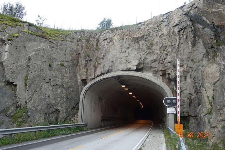 Bildet viser tunnelportalen på Napp i Lofoten. Bildeteksten sier, I dag renner det mye vann ned i Nappstraumtunnelen når det regner. Nå skal det støpes en terskel av betong under vegen for å styre regnvannet til et mindre pumpesystem uten i dagen.