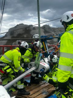 Førebuingar til trekking av første delkabel. Bilete syner arbeidarar som koplar til delkabelen til vinsjen.