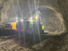 Bildet viser en hjullaster fremst i en tunnel under driving som laster sprengt stein opp i en dumper. Bildeteksten sier, Batteridrevet hjullaster under utlasting av sprengt stein i Rismålsheitunnelen på E6 Megården-Sommerset.