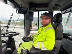 Bildet viser en sjåfør i setet på den batteridrevne hjullasteren. Bildeteksten sier, Uvant men bra: Med en hånd og en  joystick  kan den batteridrevne hjullasteren til Skanska styres uten å holde i rattet. Maskinfører Martin Ohlander sier el-maskinen må kjøres på en annen måte enn en dieselmaskin. Han mener det er en vanesak og tror el-lasterne blir vanlig i tunneldrift om noen år.
