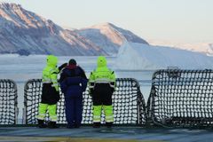 Forskerne Amandine Tisserand (NORCE), Hannah Rose Babel (UiB) og Katja Häkli (NORCE) tar en liten pause fra prøvetakingen for å se på Independence Fjords majestetiske landskap.